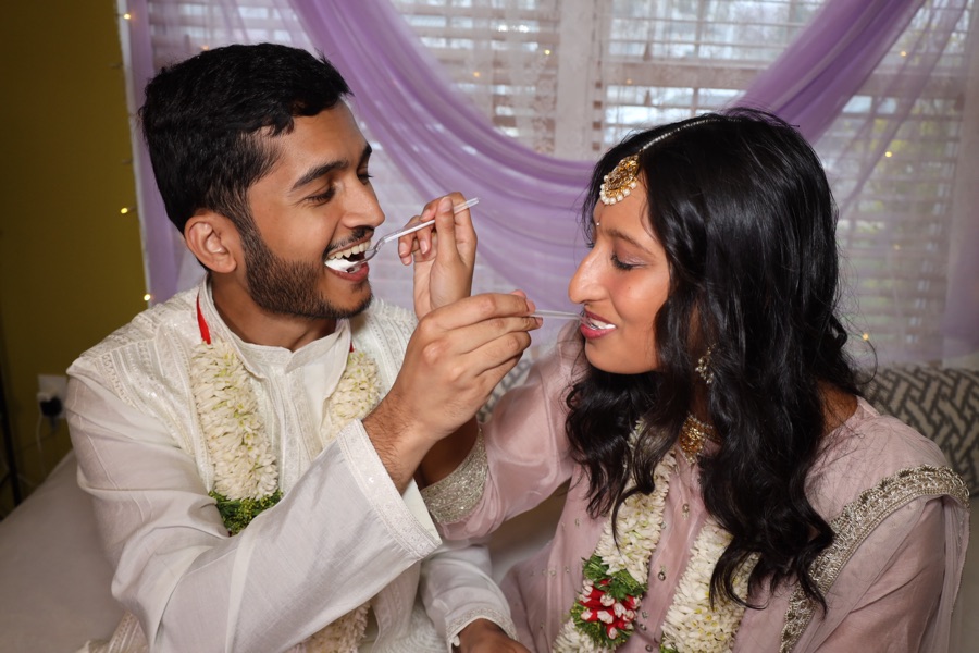 Rajul and Abdullah feeding each other cake